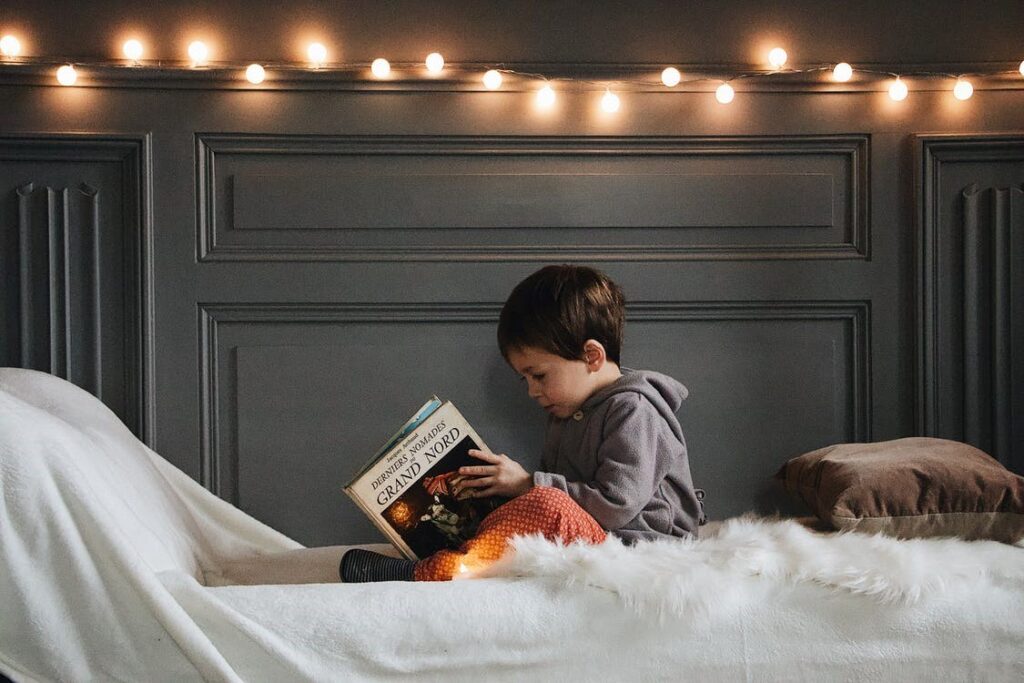 A kid reading a book in their soundproof bedroom